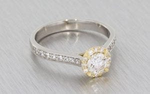 A Palladium Round Brilliant diamond halo ring housed in a 14k rose gold setting
