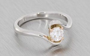 Round brilliant diamond set in a bypass shank with intricate Celtic knot detailing