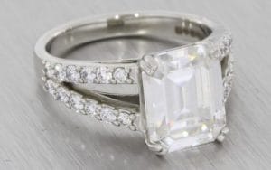 A Dramatic Split Shank Platinum Diamond And Emerald Cut Moissanite Engagement Ring