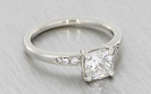 Incredible cushion cut diamond platinum ring with diamond set shoulders